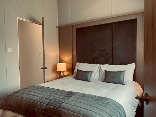 新罗姆尼Pass the Keys Luxury Lakeside Lodge的一间卧室配有一张大床和两个枕头