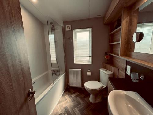 新罗姆尼Pass the Keys Luxury Lakeside Lodge的浴室配有白色卫生间和盥洗盆。