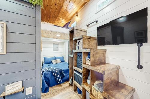 Mills RiverCozy Lakeview Cottage的一间位于一个小房子的卧室,配有电视和床