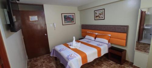 利马Aruba Suite Hotel的一间小卧室,配有一张床和电视
