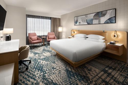 三角洲Delta Hotels by Marriott Vancouver Delta的酒店客房带一张大床和两张椅子