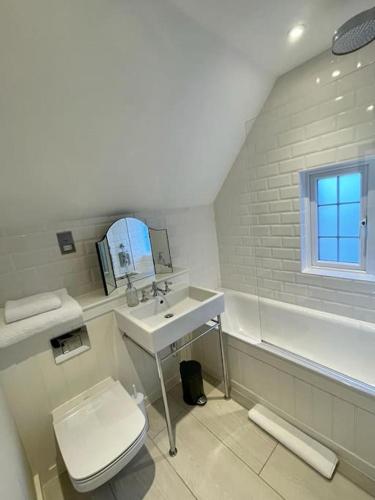 法纳姆Northbrook Cottage, Farnham, up to 8 adults的白色的浴室设有卫生间和水槽。