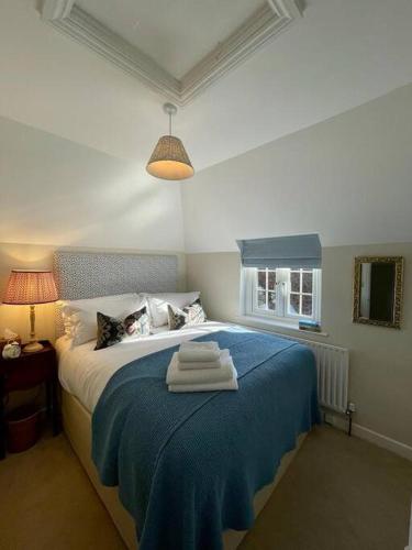 法纳姆Northbrook Cottage, Farnham, up to 8 adults的一间卧室配有蓝色的床和毛巾