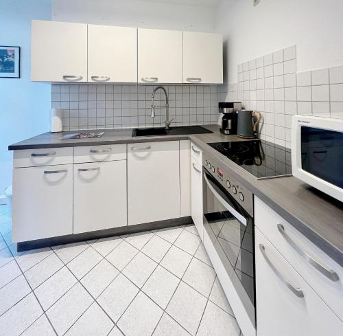 爱尔福特Atelierwohnung mit Parkblick的厨房配有白色橱柜和微波炉