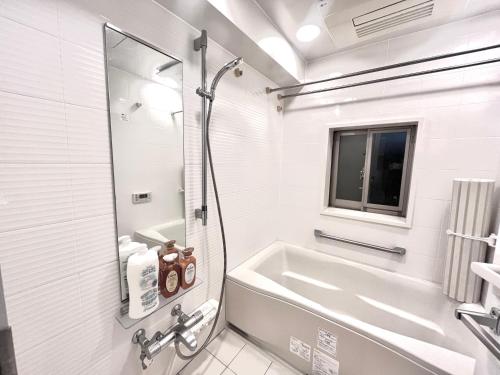东京Shibuya Harajuku big house的白色的浴室设有浴缸和水槽。