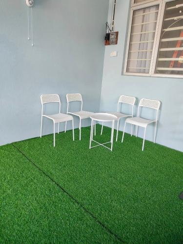 KeterehMunadibStay Private Pool的一组椅子和一张绿草桌子