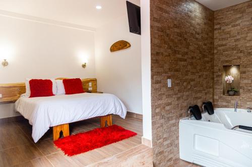 萨兰托Hospedaje Vista Hermosa Salento的一间卧室配有一张床,浴室设有浴缸