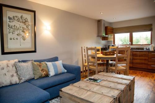 法纳姆Azalea Northbrook Park Chalet的客厅配有蓝色的沙发和桌子