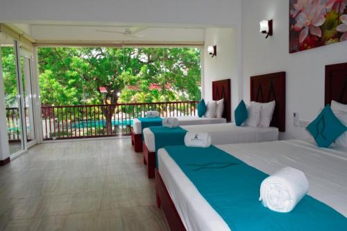 亭可马里Anantamaa Hotel的带阳台的客房内的两张床