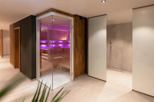 瓦雷尔Hotel Friesenhof的带玻璃隔板的客房,设有浴室