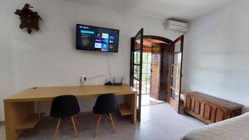 索罗卡巴Lindo estúdio perto do Hospital BOS Sorocaba (3)的客房设有一张木桌和两把椅子。