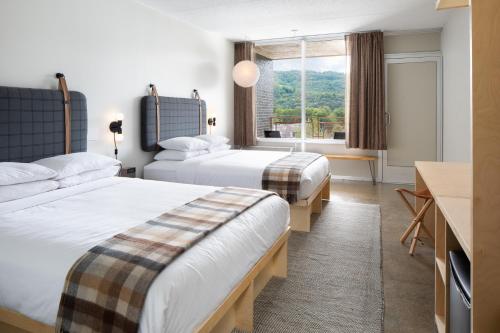 布恩Rhode's Motor Lodge的酒店客房设有两张床和窗户。