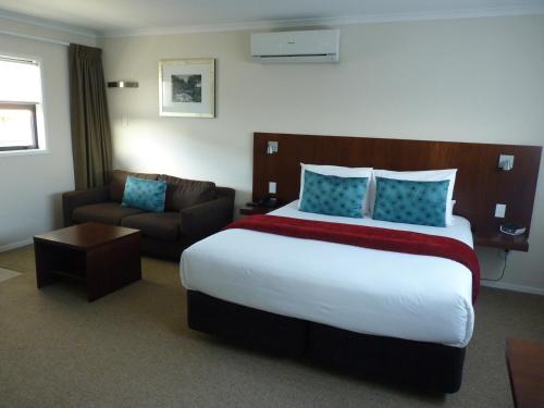 汉密尔顿阿斯特拉汽车旅馆的酒店客房设有一张大床和一张沙发。