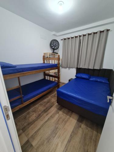 卡拉瓜塔图巴Apartamento na Praia Martim de Sá com linda vista的一间卧室设有两张双层床和一扇窗户。