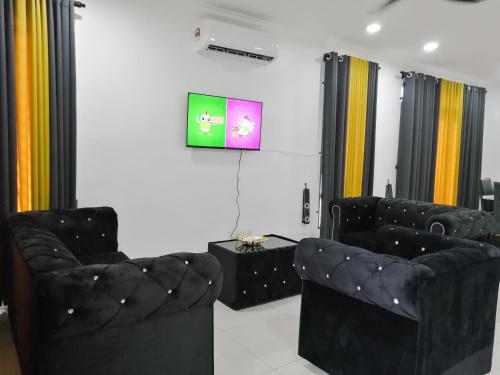 双溪大年Marvelous Homestay SP Kedah的客厅配有2把黑色椅子和电视