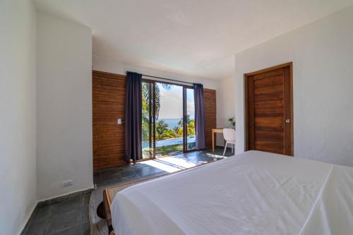 Monte RojoHacienda Cocuyo的卧室设有白色的床和大窗户