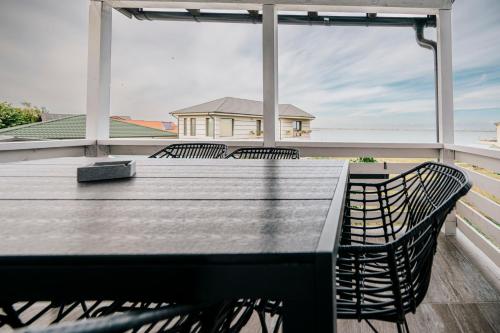 那沃达利Lake House的阳台配有桌椅,享有房屋美景