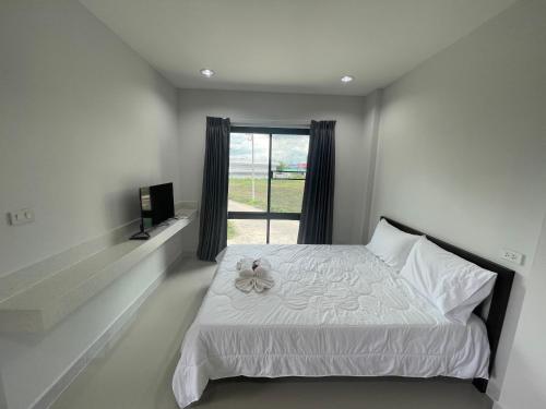 Ban Khok KhamW residence สมุทรสาคร的卧室配有白色的床和窗户。