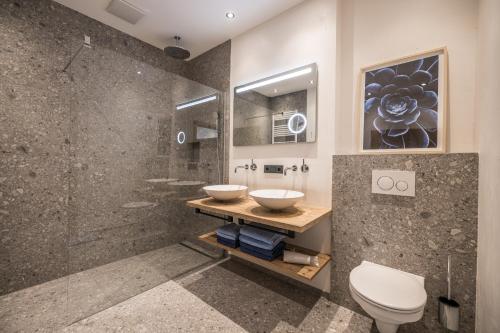 迈尔霍芬Natur Zeit - Alpine Garden Apartments的一间带两个盥洗盆和淋浴的浴室