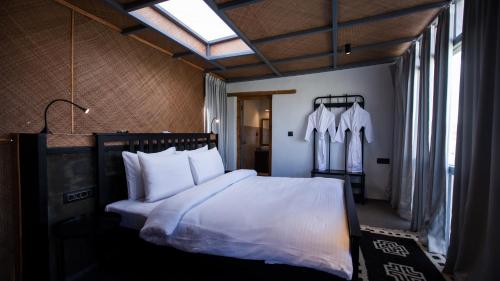 MerukThe Merak的一间卧室配有带白色床单和枕头的床。