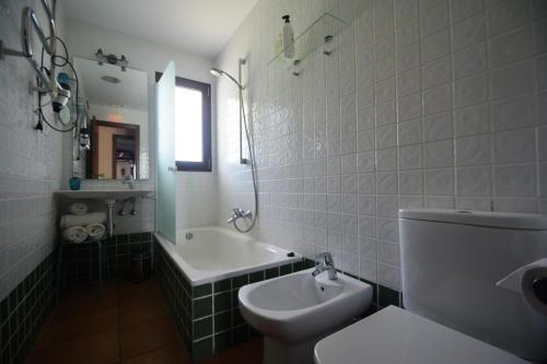 阿拉哈尔Posada San Marcos的浴室配有卫生间、浴缸和水槽。