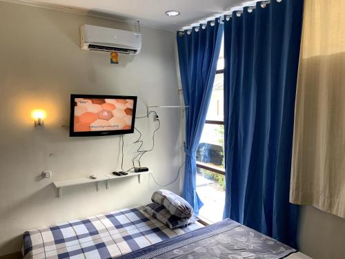 日惹Awana Dream 4 bedrooms house , 5min to Alun Alun, Kraton, Malioboro bdc的卧室配有一张床,墙上配有电视。