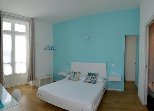 CastroCa del Lac Rooms的卧室配有白色床和蓝色墙壁