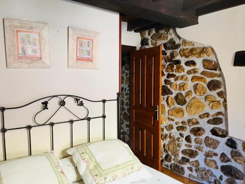 Las Rozas迭戈公寓的一间卧室设有一张床和石墙
