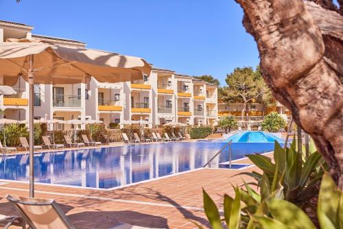 阿尔库迪亚港扎菲罗热带公寓的酒店游泳池设有椅子和遮阳伞