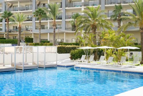 阿尔库迪亚港萨菲罗宫西拉斯酒店的大楼前的游泳池配有椅子和遮阳伞