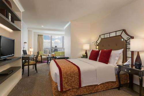 马尼拉Discovery Suites Manila, Philippines的酒店客房,配有床和电视