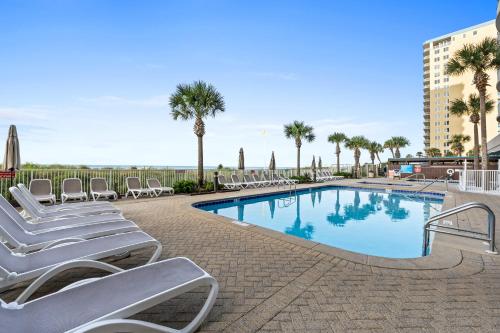 巴拿马城海滩Ocean Villa by Panhandle Getaways的一个带躺椅的游泳池,棕榈树