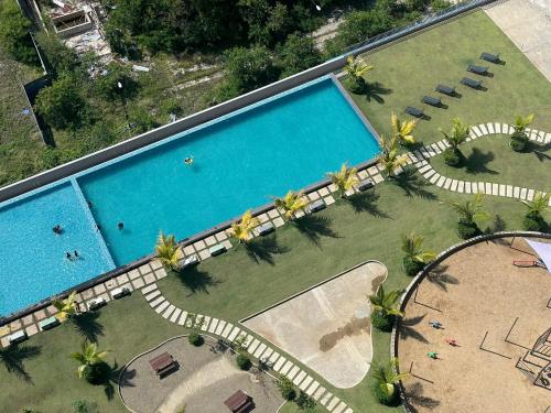 哥打京那巴鲁LW Suite at JQ Seaview 2BR High Floor & Wi-Fi的享有棕榈树游泳池的顶部景致