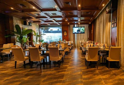 富查伊拉城市大厦酒店 的餐厅设有桌椅和平面电视。
