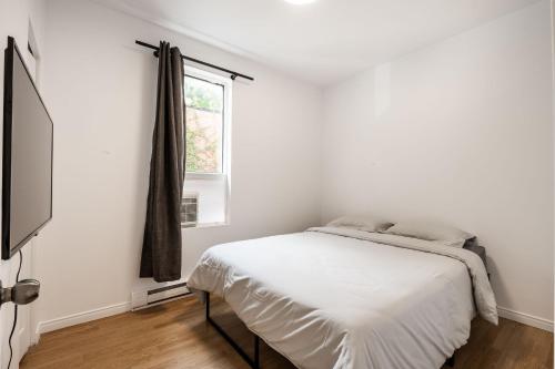 蒙特利尔Appartement 1 chambre 1 lit queen-1009的白色的卧室设有床和窗户