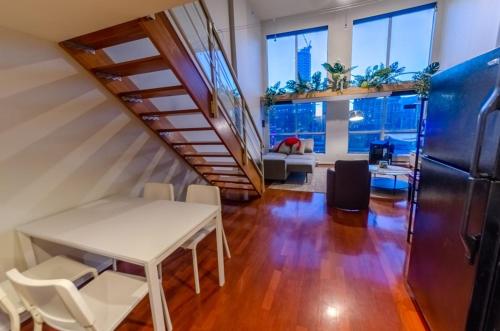 温哥华loft in downtown Vancouver with free parking的一个带楼梯和桌椅的办公室