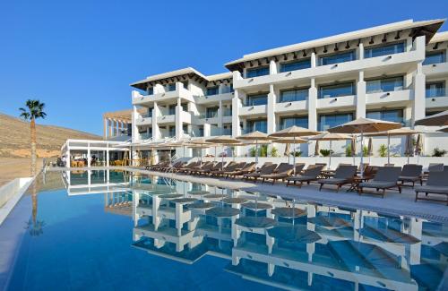 科斯塔卡玛INNSiDE by Meliá Fuerteventura – Adults Only的酒店设有带椅子和遮阳伞的游泳池