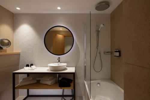 巴塞罗那加泰罗尼亚对角线中心酒店的一间带水槽、淋浴和镜子的浴室