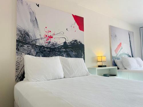 基西米A & S Vacation Rooms的卧室配有白色的床和墙上的绘画作品