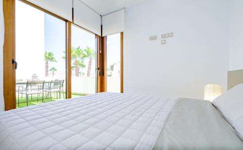 弗拉门卡海滩Secreto De La Zenia ID200的一间带一张白色大床的卧室和一个阳台