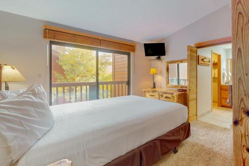 布雷肯里奇Pine Ridge 05E的卧室设有一张白色大床和一扇窗户。