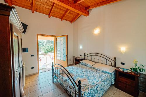 阿尔布斯Agriturismo Rocce Bianche - Porticato的一间卧室设有一张床,并有通往庭院的门