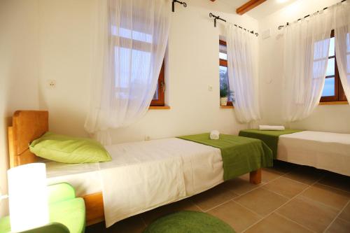 扎达尔爱里尔之家度假屋的一间卧室设有两张床和两个窗户。