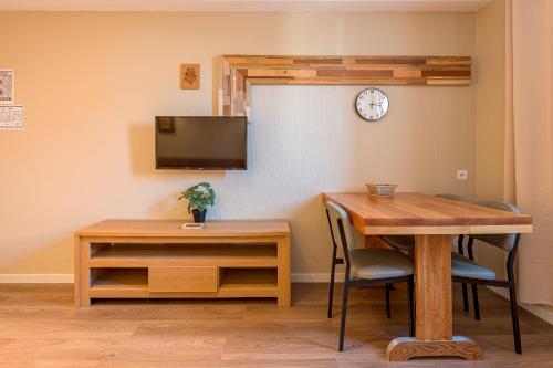 EnnezatRésidence L'Atelier的一间设有桌子和墙上时钟的餐厅