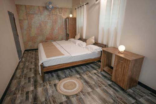VaragampadiQatsyir Horizon的一间小卧室,配有一张床和一张桌子