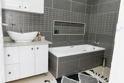 派恩敦Sapphire Guesthouse的浴室配有盥洗盆和浴缸。