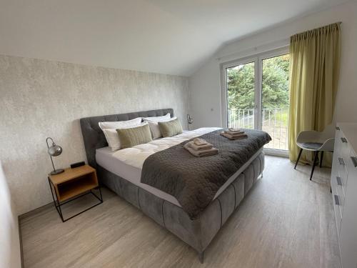 弗赖贝格ZugZuflucht-neues, modernes Ferienhaus的一间卧室设有一张大床和一个窗户。