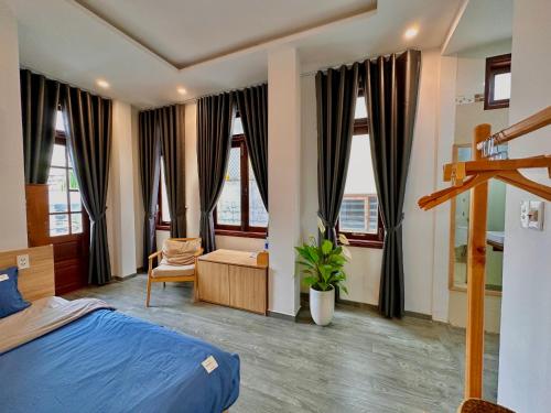 岘港ChiPa Homestay的一间卧室配有一张床、一把椅子和窗户。