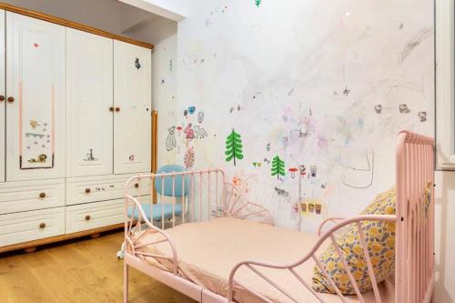 伊斯坦布尔4 Bedroom Spacious Apartment in Nisantasi的一间设有粉红色婴儿床的幼儿园,房间墙上贴着标签