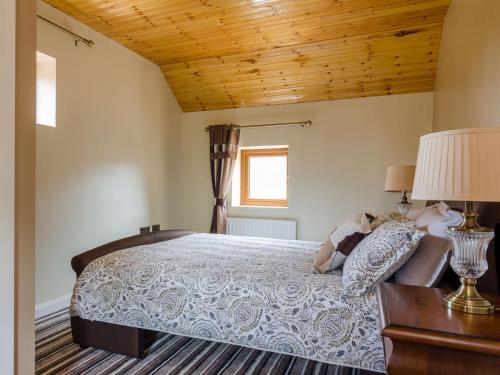 利斯本Avoca Lodge的一间卧室设有一张床和木制天花板